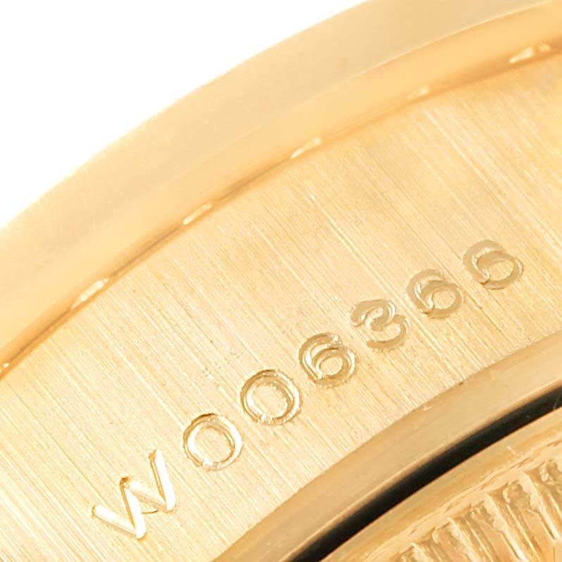 This close-up image shows part of the gold case with engraved numbers on a Rolex President 69158 Women's Yellow Gold Grey Dial 69158 Women's Yellow Gold Grey Dial model watch.