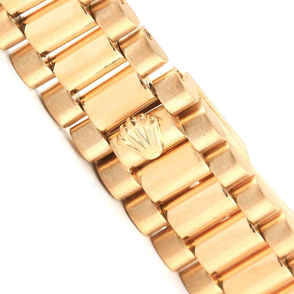 The image shows a close-up of the gold bracelet, including the Rolex crown emblem, of a Rolex President 79138 Women's Yellow Gold Champagne Dial 79138 Women's Yellow Gold Champagne Dial model watch.