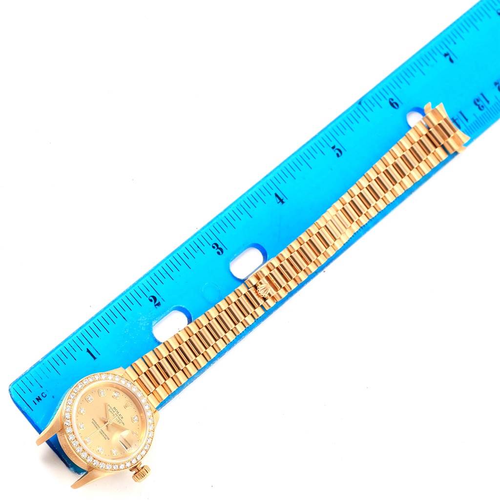 The image shows the face and full bracelet of a Rolex President 79138 Women's Yellow Gold Champagne Dial 79138 Women's Yellow Gold Champagne Dial model watch next to a blue ruler for scale.