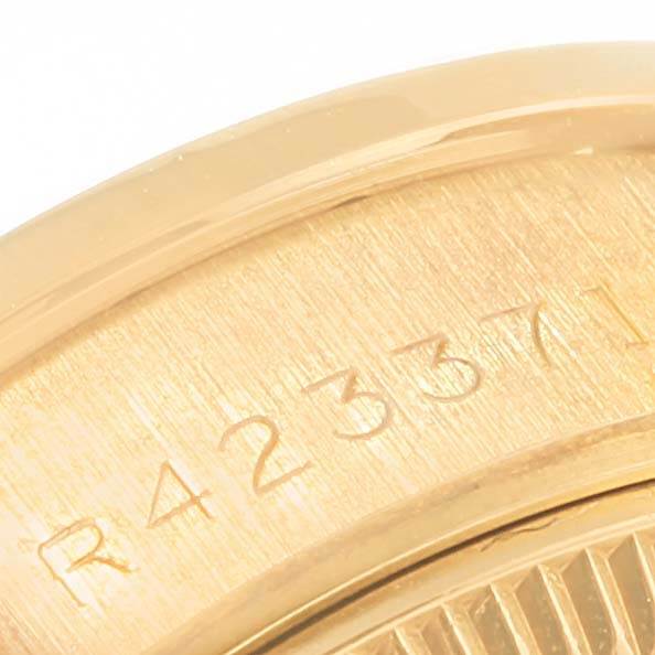 This close-up image shows a portion of the back case of a Rolex President 69158 Women's Yellow Gold Champagne Dial 69158 Women's Yellow Gold Champagne Dial model watch, highlighting the engraved serial number.