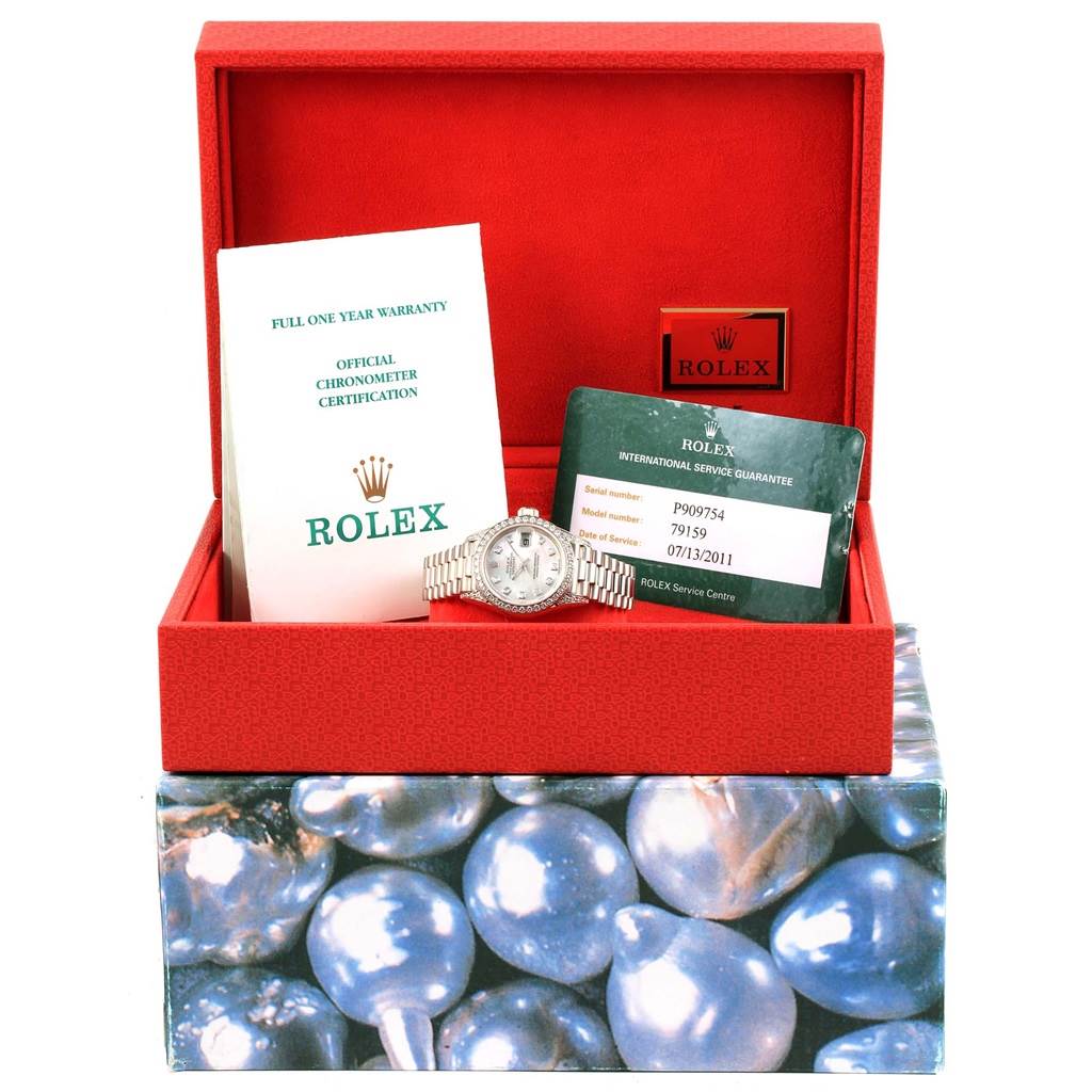 The image shows a Rolex President 79159 Women's White Gold Mother of Pearl Dial 79159 Women's White Gold Mother of Pearl Dial watch along with its warranty card, certification, and box, viewed from the front.