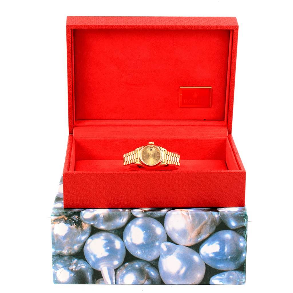 The Rolex President 69178 Women
s Yellow Gold Champagne Dial 69178 Women
s Yellow Gold Champagne Dial watch is shown in its open red box, revealing the watch and part of the gold-colored bracelet.