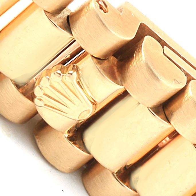 This close-up image shows the gold bracelet links and the Rolex crown logo on the President model watch by Rolex.