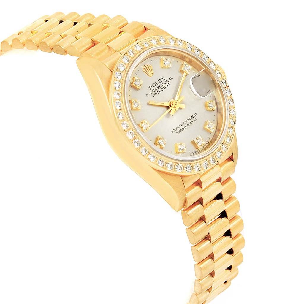 The image shows a side angle of a Rolex President 69138 Women's Yellow Gold Silver Dial 69138 Women's Yellow Gold Silver Dial model watch, highlighting its gold band, diamond bezel, and dial.