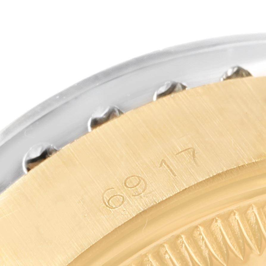 This close-up angle of the Rolex President 6917 Women
s Yellow Gold Champagne Dial 6917 Women
s Yellow Gold Champagne Dial model watch shows the bezel and part of the case with the engraved model number "6917."