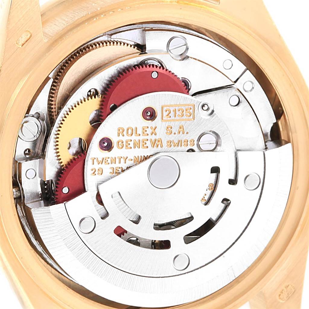The image shows the internal mechanism of a Rolex President 69288 Women
s Yellow Gold White Dial 69288 Women
s Yellow Gold White Dial model watch at a close-up angle, highlighting gears and inscriptions.