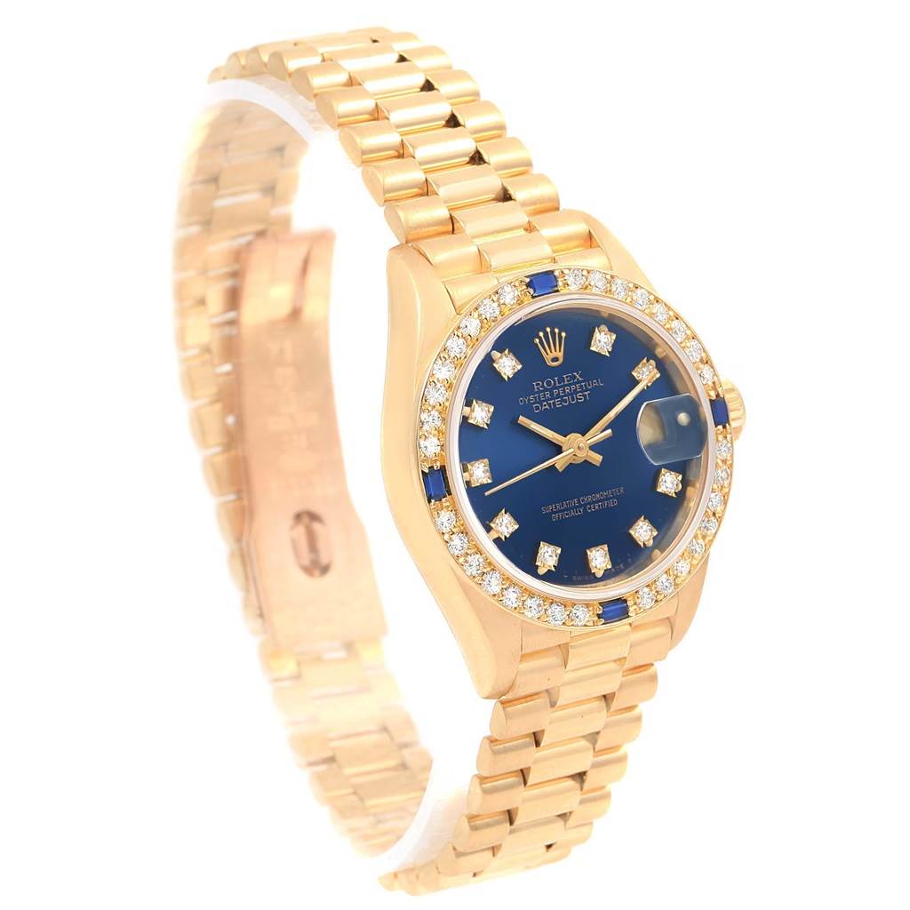 The image shows a Rolex President 69178 Women's Yellow Gold Blue Dial 69178 Women's Yellow Gold Blue Dial model watch at a slight angle, highlighting its gold case, diamond bezel, and blue dial.