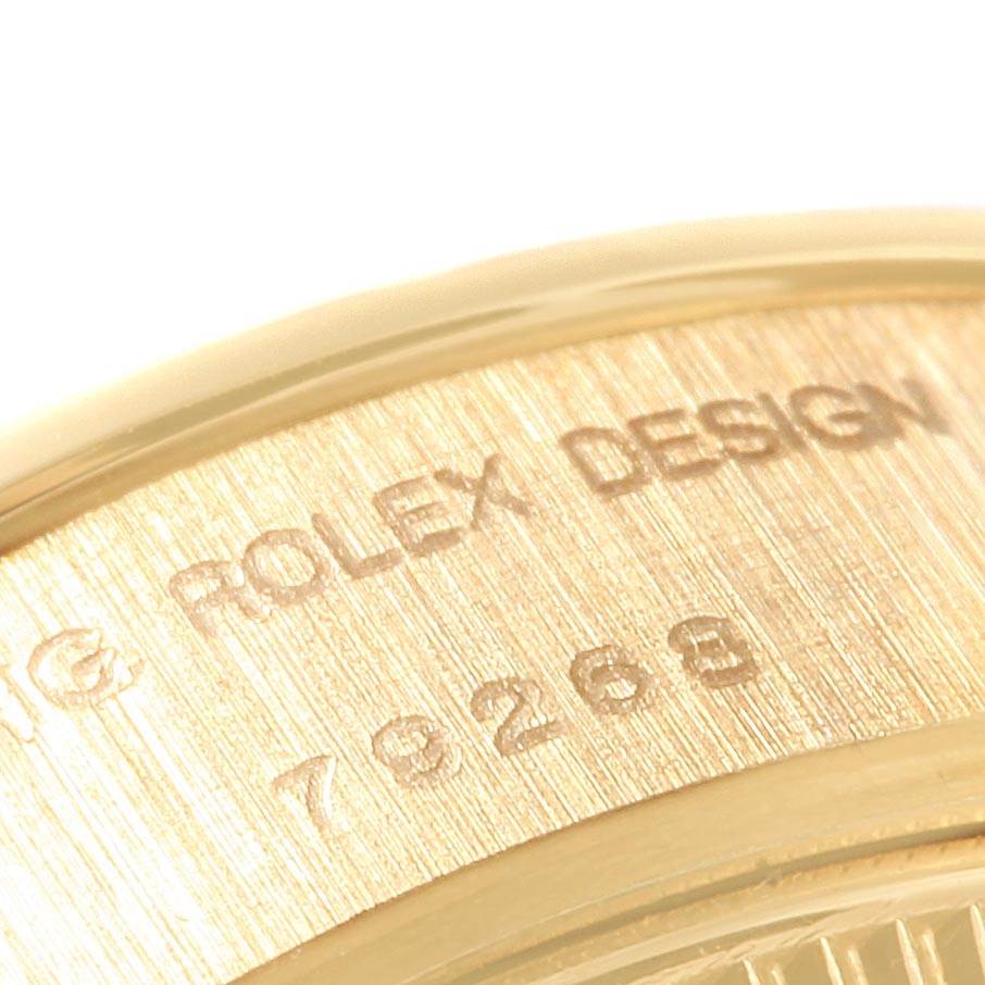 This image shows a close-up of the case side of a Rolex President 79268 Women
s Yellow Gold Champagne Dial 79268 Women
s Yellow Gold Champagne Dial model, displaying the engraving "ROLEX DESIGN" and the model number.