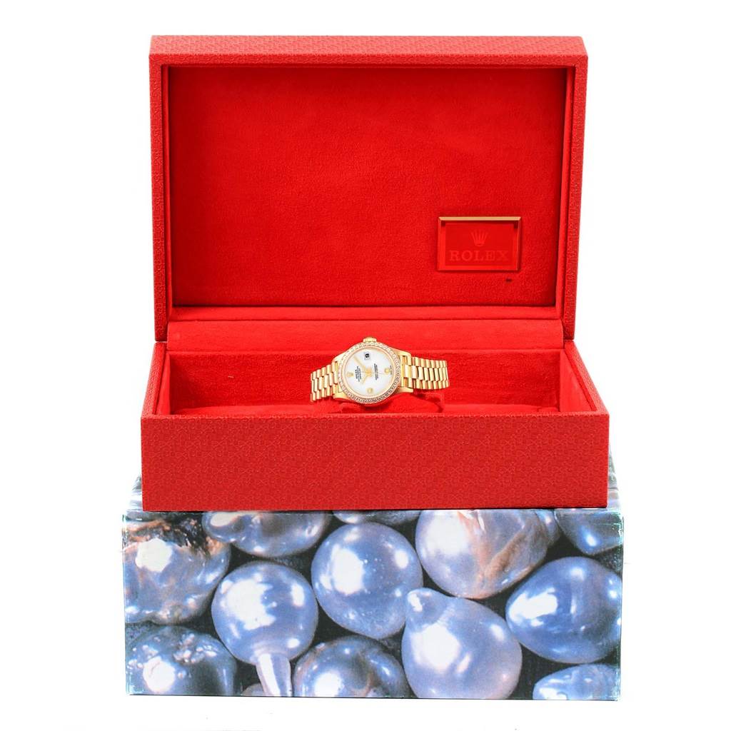 The Rolex President 79138 Women
s Yellow Gold White Dial 79138 Women
s Yellow Gold White Dial watch is displayed face-up in an open red box with a cushioned interior and a Rolex logo inside the lid.