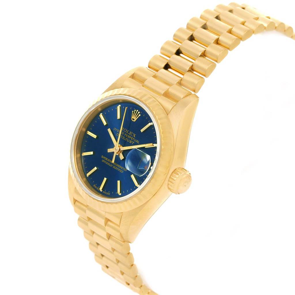 The image shows a Rolex President 69178 Women's Yellow Gold Blue Dial 69178 Women's Yellow Gold Blue Dial model watch at an oblique angle, highlighting the gold bracelet, blue dial, and side crown.