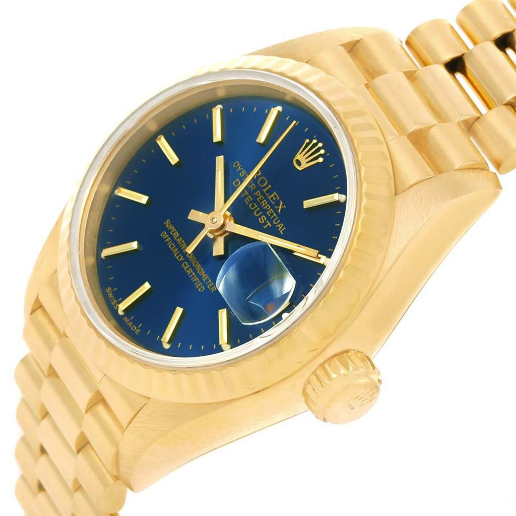 The image shows the Rolex President 69178 Women's Yellow Gold Blue Dial 69178 Women's Yellow Gold Blue Dial model watch at an angled view, highlighting its gold bracelet, blue dial, and fluted bezel.