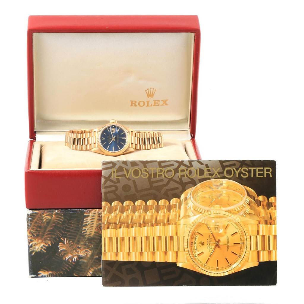 The Rolex President 69178 Women's Yellow Gold Blue Dial 69178 Women's Yellow Gold Blue Dial model watch is shown inside its open box with an instruction manual displaying images of the watch.