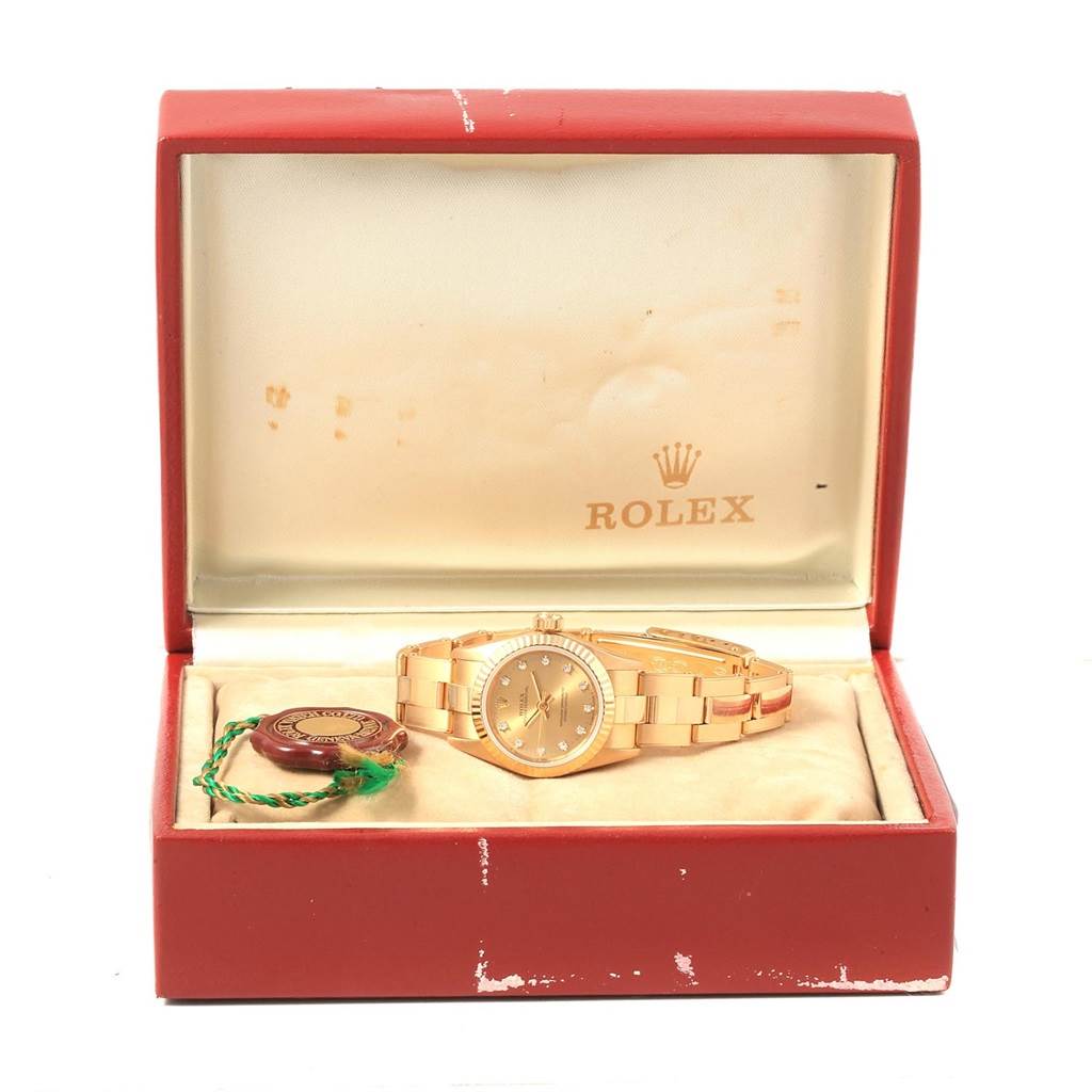 The Rolex President 67198 Women
s Yellow Gold Champagne Dial 67198 Women
s Yellow Gold Champagne Dial watch is displayed inside an open box with a tag next to it.