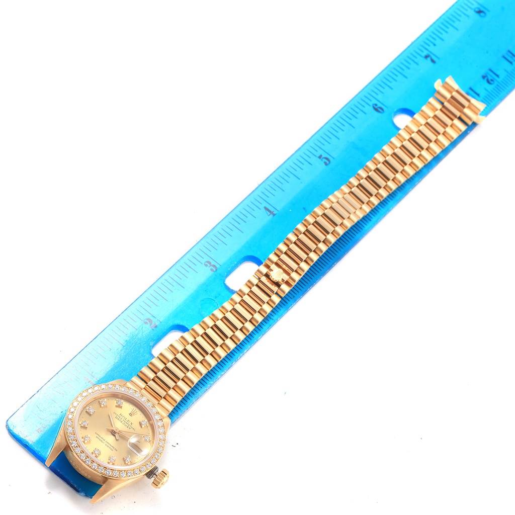 The image shows a top view of a Rolex President 69178 Women's Stainless Steel Champagne Dial 69178 Women's Stainless Steel Champagne Dial model watch, including the face, bezel, and bracelet, with a ruler for scale.