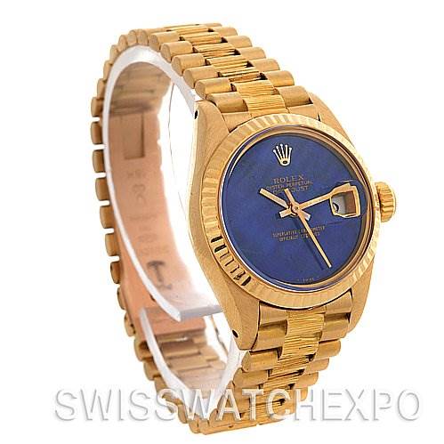 The watch shows a front-side angle, displaying the Rolex President 6917 Women's Yellow Gold Blue Dial 6917 Women's Yellow Gold Blue Dial model's golden bracelet, blue dial, and fluted bezel.