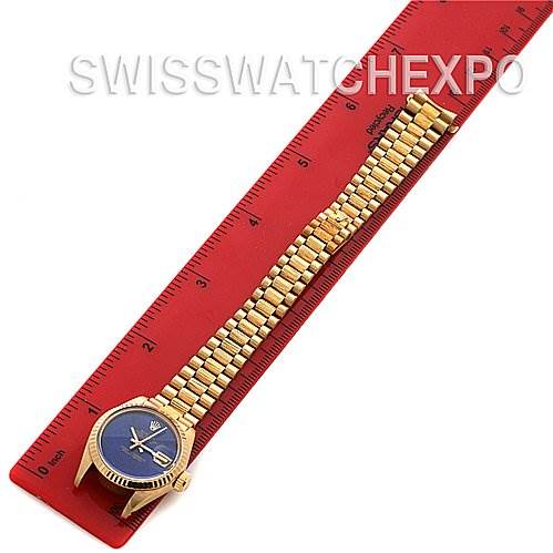 The image shows the full front view of a Rolex President 6917 Women's Yellow Gold Blue Dial 6917 Women's Yellow Gold Blue Dial watch, laid flat alongside a red ruler.