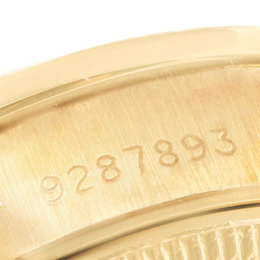 This image shows the engraved serial number on the gold casing of a Rolex President 69178 Women's Yellow Gold Orange Dial 69178 Women's Yellow Gold Orange Dial model watch.