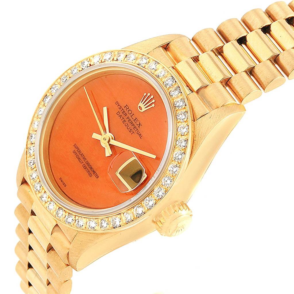 The image shows a close-up angle of the Rolex President 69178 Women's Yellow Gold Orange Dial 69178 Women's Yellow Gold Orange Dial model watch, highlighting the dial, crown, and part of the bracelet.