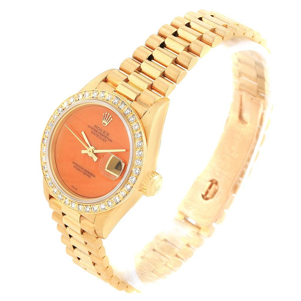 This image shows a Rolex President 69178 Women's Yellow Gold Orange Dial 69178 Women's Yellow Gold Orange Dial model watch from an angled view, highlighting its face, bezel, and part of its bracelet.