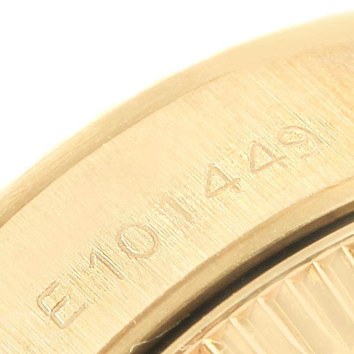 This close-up image shows the edge of a gold bezel from a Rolex President 67198 Women
s Yellow Gold Champagne Dial 67198 Women
s Yellow Gold Champagne Dial model watch with serial number engraving.