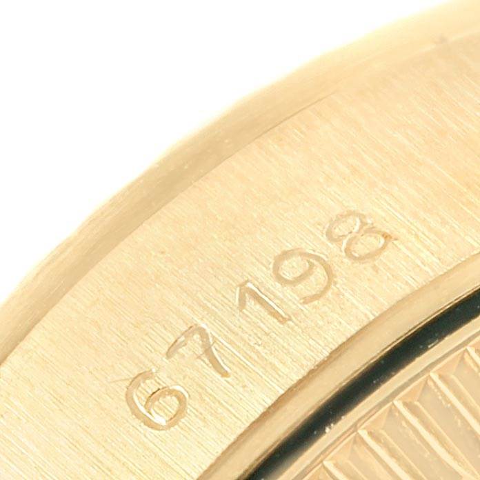 This close-up shows a portion of the bezel and case with an engraved serial number on the Rolex President 67198 Women
s Yellow Gold Champagne Dial 67198 Women
s Yellow Gold Champagne Dial model watch.