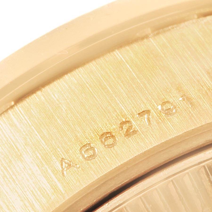 This close-up image shows the serial number engraved on the gold casing of a Rolex President 79088 Women's Yellow Gold Black Dial 79088 Women's Yellow Gold Black Dial model watch.