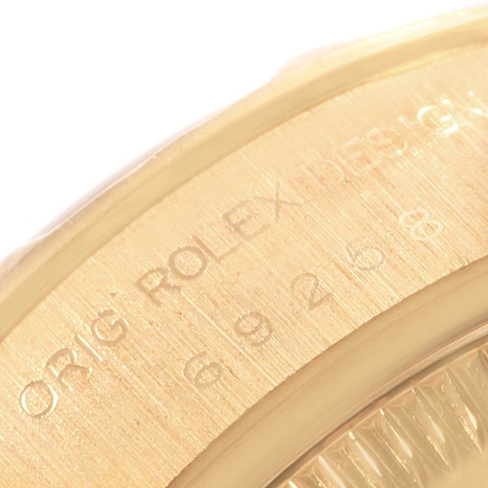 The image shows a close-up of the engraved bezel edge and dial of a Rolex President 69258 Women's Yellow Gold Champagne Dial 69258 Women's Yellow Gold Champagne Dial model watch.