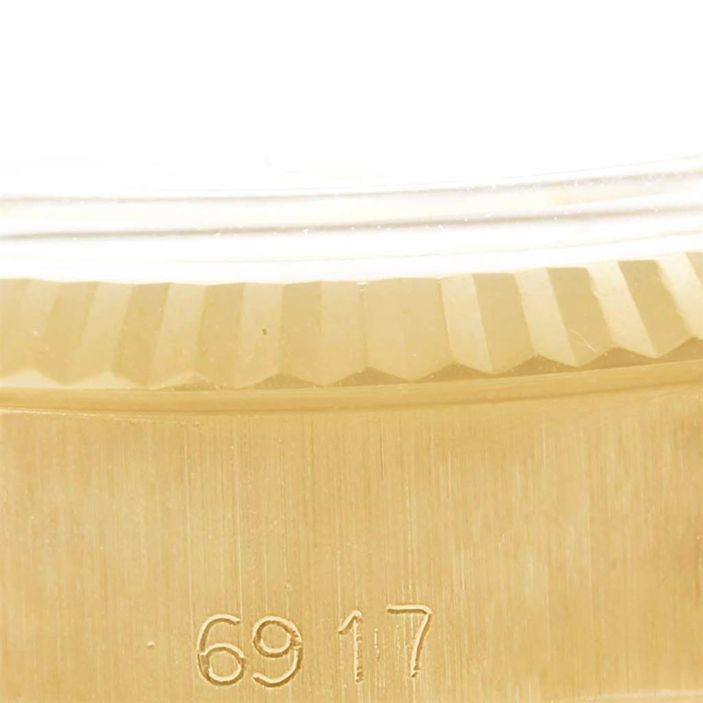 The image shows a close-up of the fluted bezel and case of a President model Rolex watch, with engraved numbers visible.