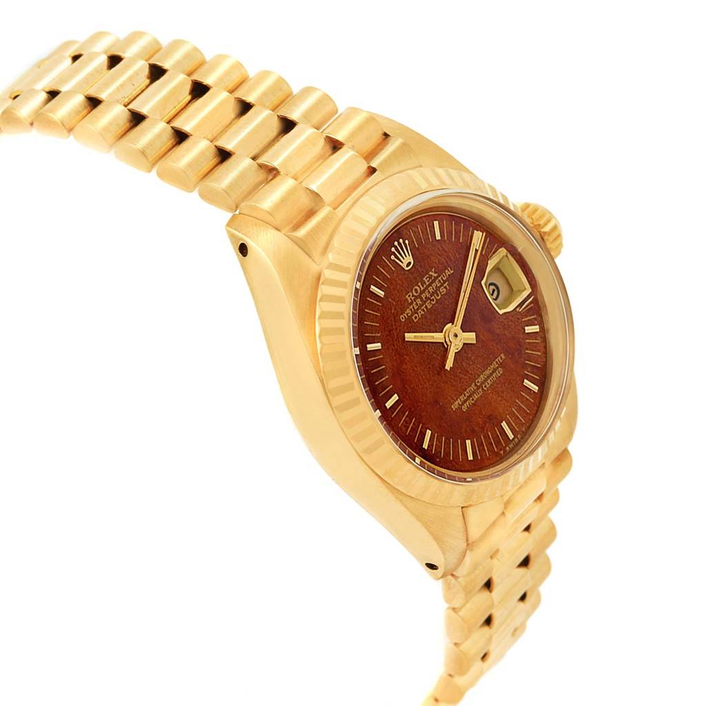 This image shows a Rolex President 6917 Women's Yellow Gold Brown Dial 6917 Women's Yellow Gold Brown Dial model watch angled from the side, displaying its gold bracelet, bezel, and a portion of the dial with the date window.