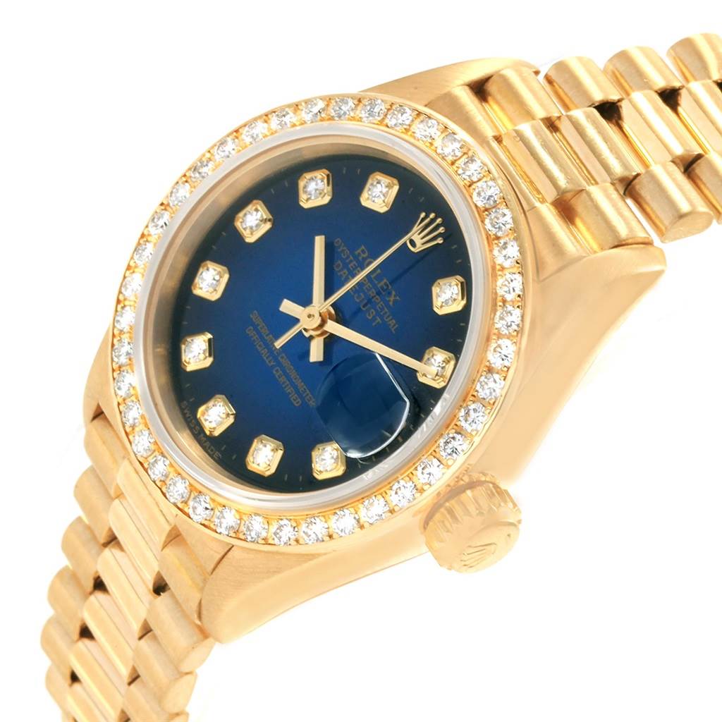 The image shows a close-up angle of a Rolex President 69138 Women's Yellow Gold Blue Dial 69138 Women's Yellow Gold Blue Dial model watch, highlighting the bezel, crown, bracelet, and dial.