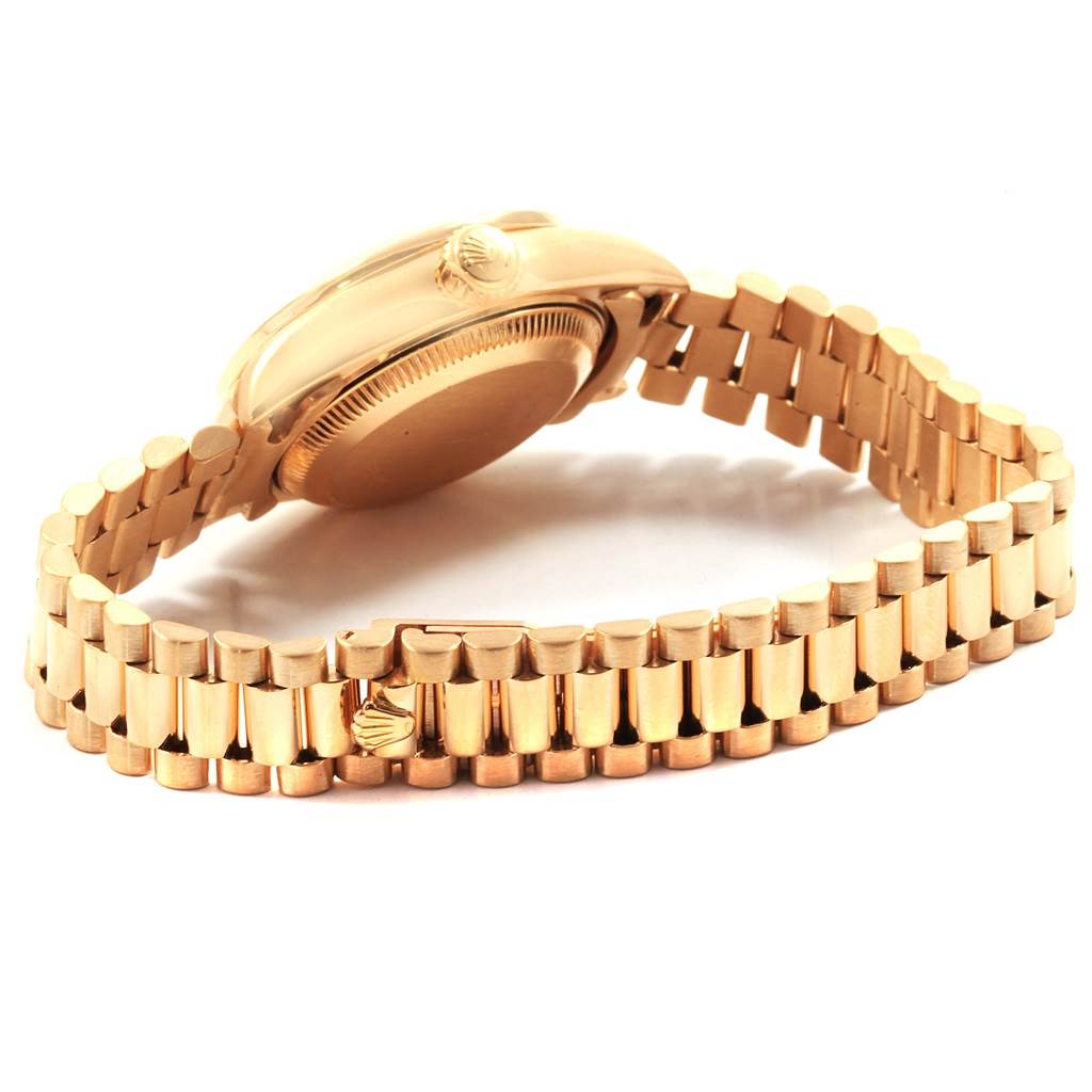 The image shows the side and back of a Rolex President 69138 Women's Yellow Gold Blue Dial 69138 Women's Yellow Gold Blue Dial model watch with its gold bracelet visible.