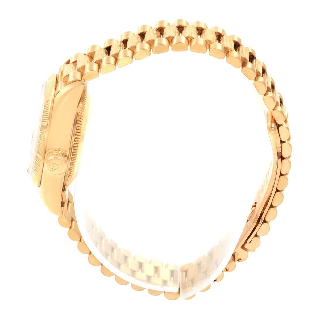 The image shows a side view of a Rolex President 69038 Women's Yellow Gold Champagne Dial 69038 Women's Yellow Gold Champagne Dial model watch, highlighting its golden case and intricate bracelet.