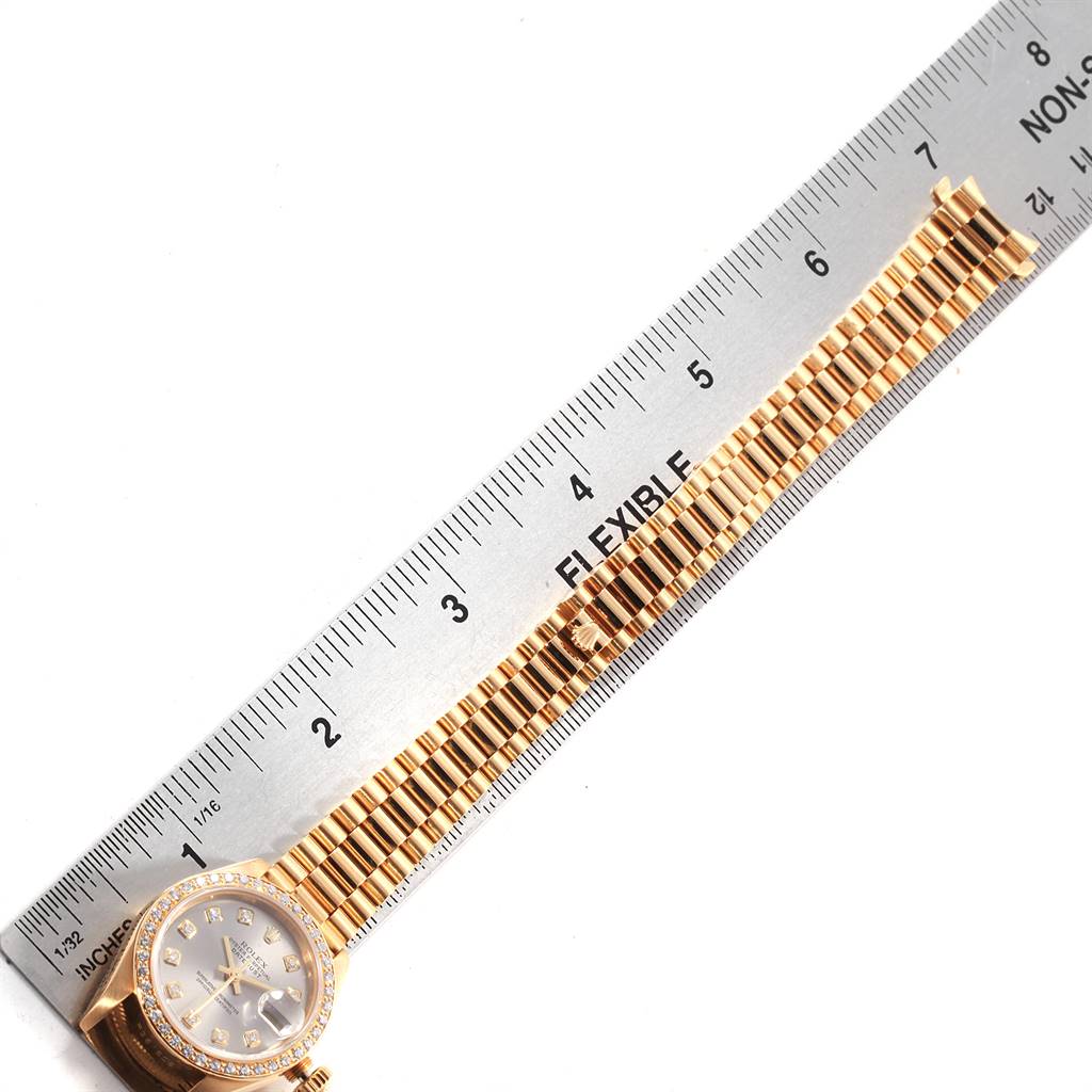 The Rolex President 69178 Women's Yellow Gold Silver Dial 69178 Women's Yellow Gold Silver Dial model watch is shown flat with its band extended alongside a ruler for measurement.