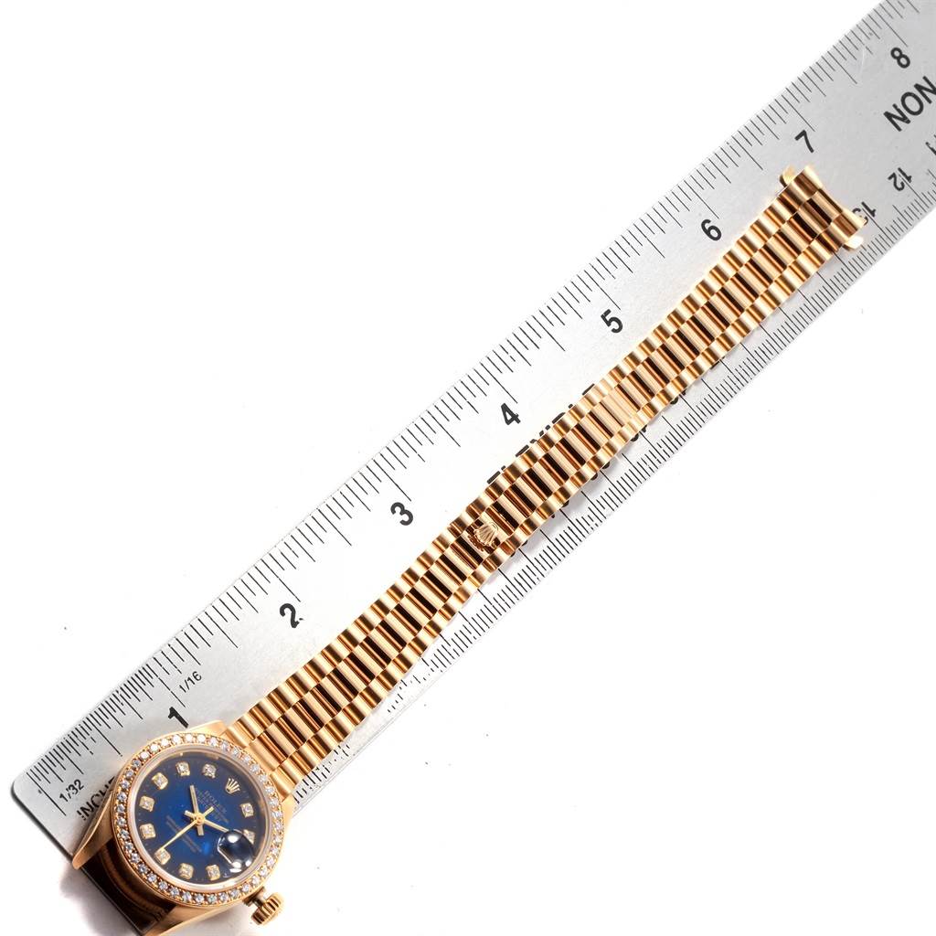 The image shows a Rolex President 69178 Women's Yellow Gold Blue Dial 69178 Women's Yellow Gold Blue Dial model watch with a gold band and blue dial, positioned next to a ruler.