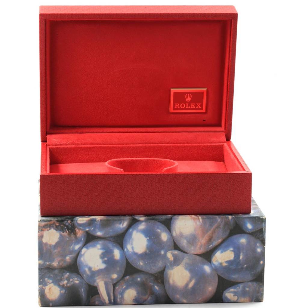 This image shows an open red Rolex case with a slot for a President model watch.