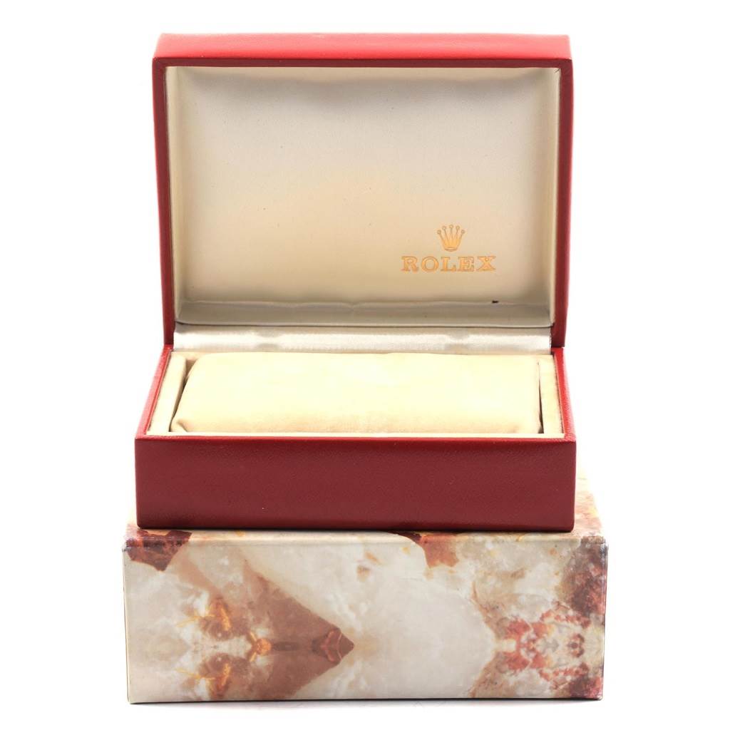 The image shows an open Rolex watch box for the President model, showcasing the interior cushion and packaging.