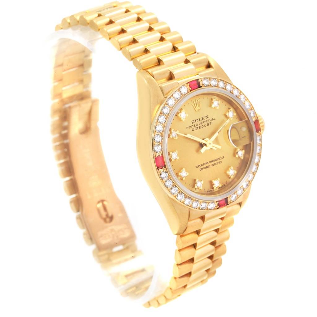 This image shows the President model by Rolex from an angled top view, featuring its gold bezel, bracelet, and diamond-encrusted dial.