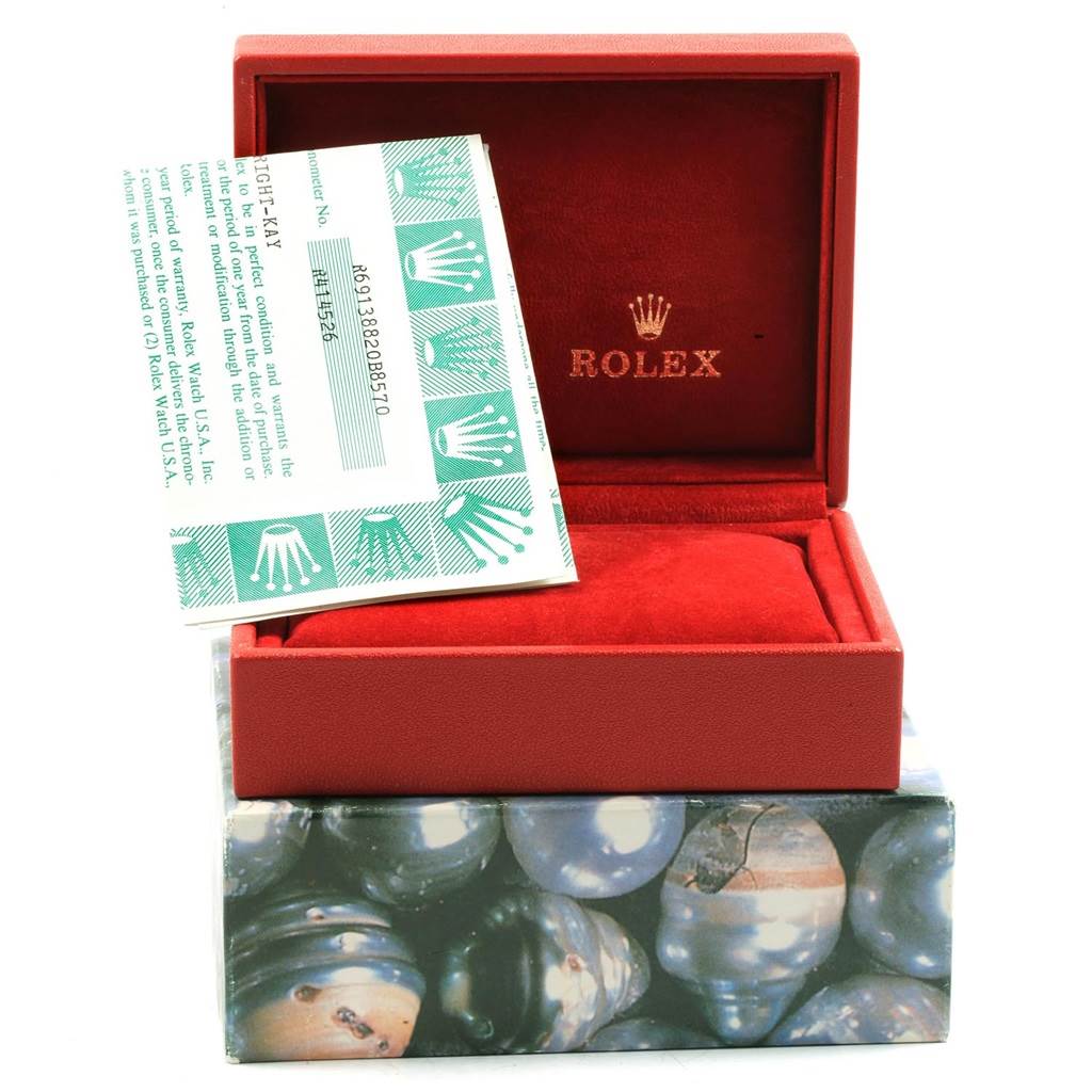 The image shows a Rolex President 69138 Women
s Yellow Gold Black Dial 69138 Women
s Yellow Gold Black Dial watch box, a certificate, and a partially visible outer box.