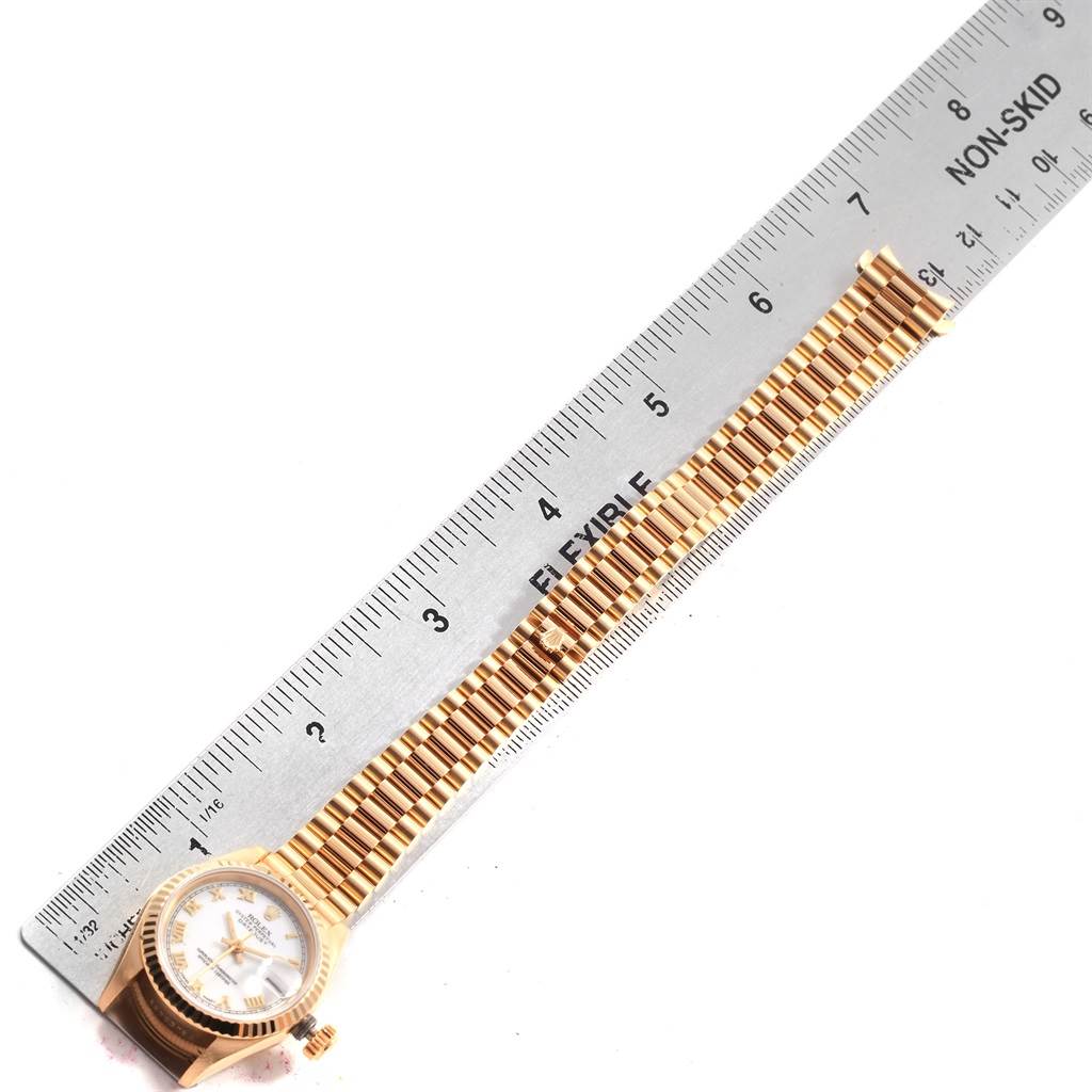 The Rolex President 69178 Women's Yellow Gold White Dial 69178 Women's Yellow Gold White Dial model watch is shown from a top view, featuring the band and part of the watch face against a ruler for measurement.