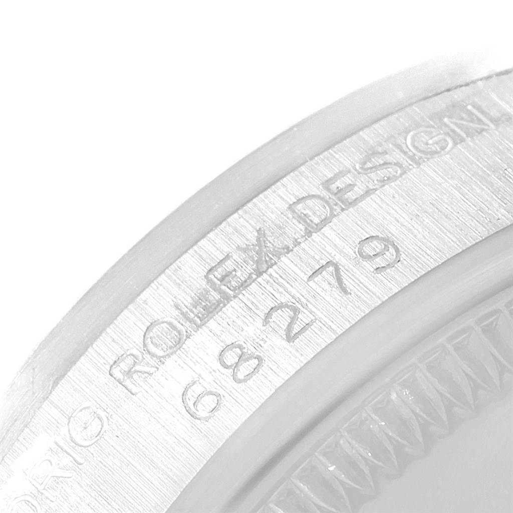 The image shows the edge of a Rolex President 68279 Women's White Gold Silver Dial 68279 Women's White Gold Silver Dial model watch with part of its serial number engraved.