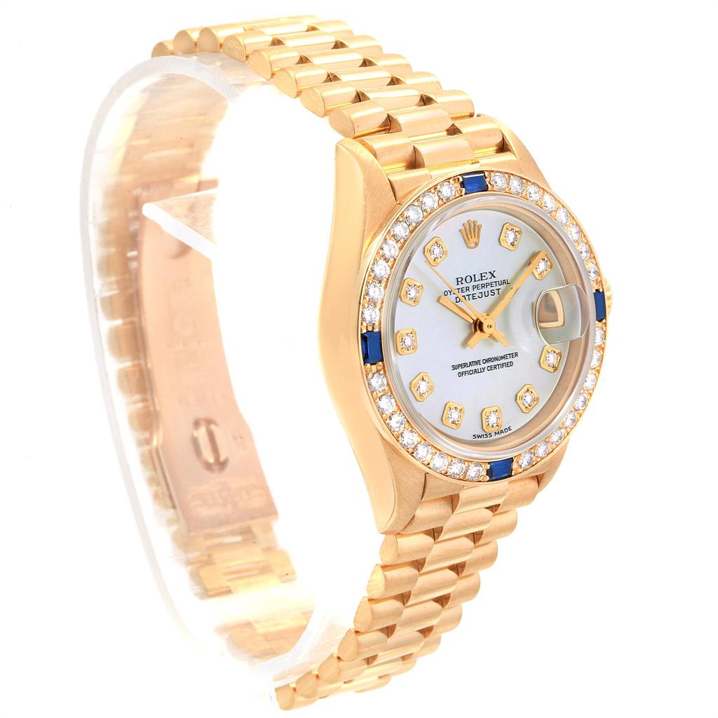 The Rolex President 79088 Women
s Yellow Gold Mother of Pearl Dial 79088 Women
s Yellow Gold Mother of Pearl Dial model watch is shown at an angled side view, highlighting its gold bracelet, diamond bezel, and face.