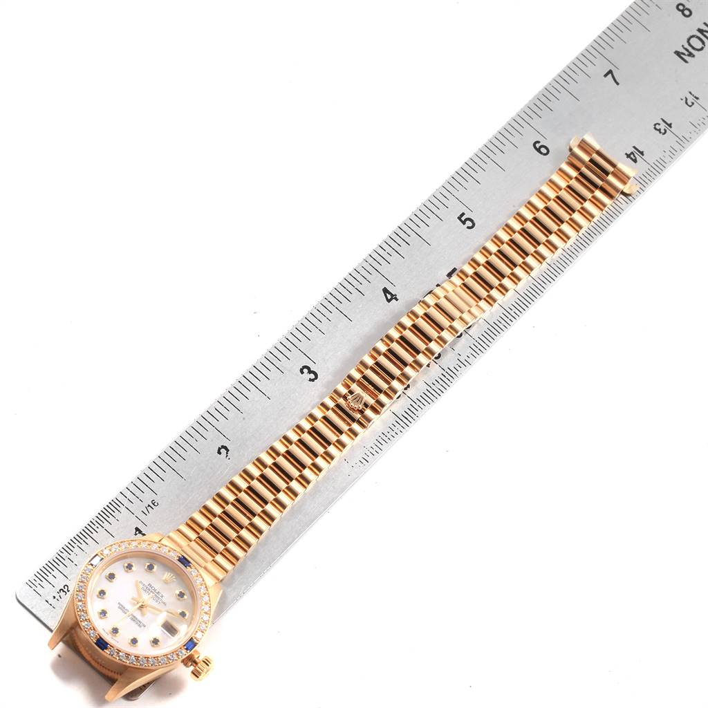 The image shows a Rolex President 79088 Women's Yellow Gold Mother of Pearl Dial 79088 Women's Yellow Gold Mother of Pearl Dial model watch laid flat with a metal ruler measuring its band length.