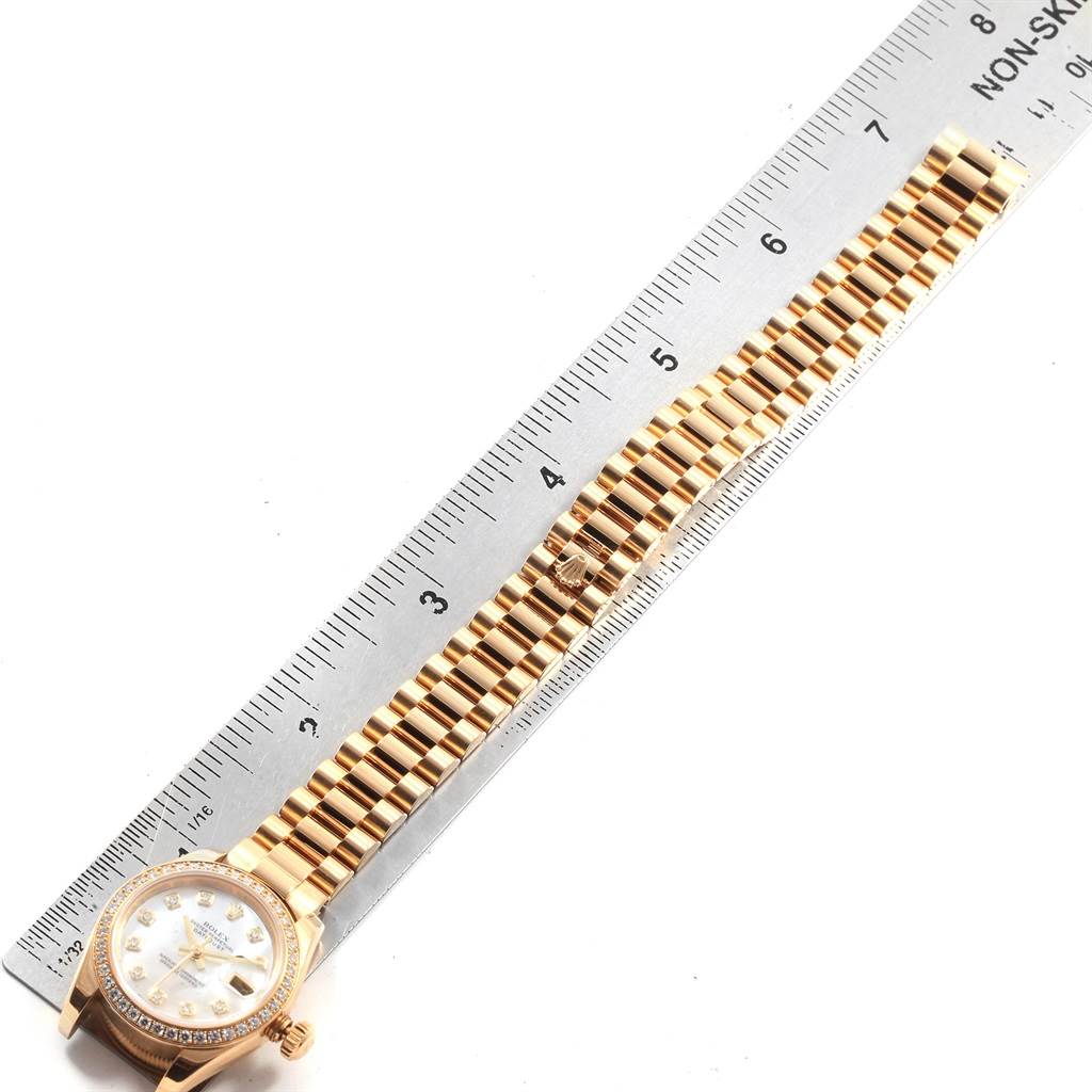 This image shows a Rolex President 179138 Women's Yellow Gold Mother of Pearl Dial 179138 Women's Yellow Gold Mother of Pearl Dial model watch from above, highlighting its face and gold bracelet alongside a ruler.