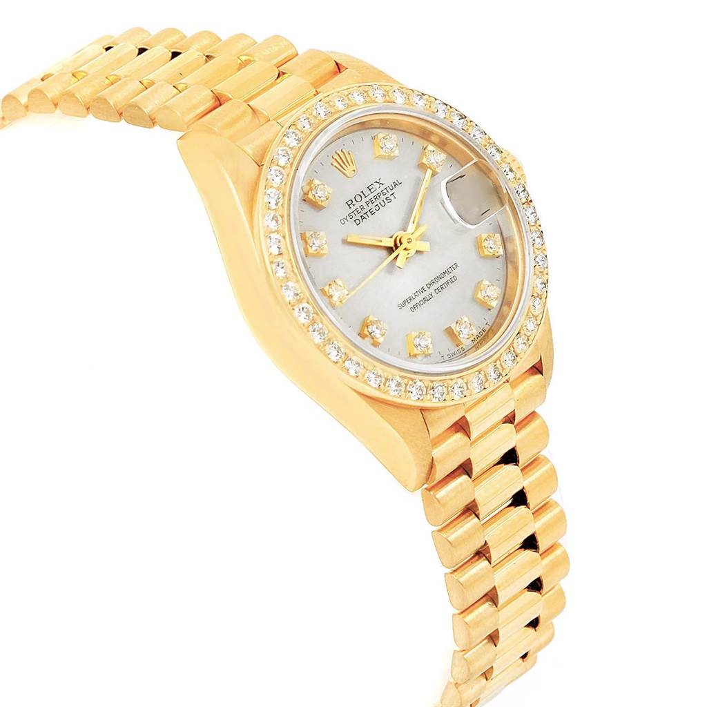 The image shows a side view of a Rolex President 69178 Women
s Yellow Gold Silver Dial 69178 Women
s Yellow Gold Silver Dial watch, highlighting its gold band, diamond-encrusted bezel, and face.