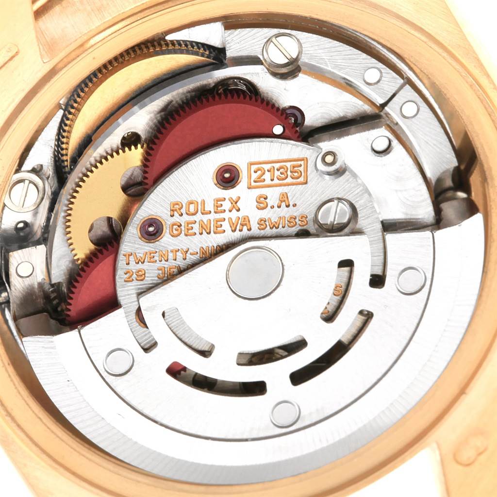 The image shows the internal mechanics and movement of a Rolex President 69158 Women's Yellow Gold Silver Dial 69158 Women's Yellow Gold Silver Dial model's watch case, including gears and engravings.
