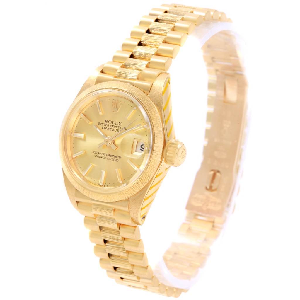 The image shows a side-angle view of a Rolex President 6927 Women's Yellow Gold Champagne Dial 6927 Women's Yellow Gold Champagne Dial model watch, highlighting its gold face, bracelet, and date display.