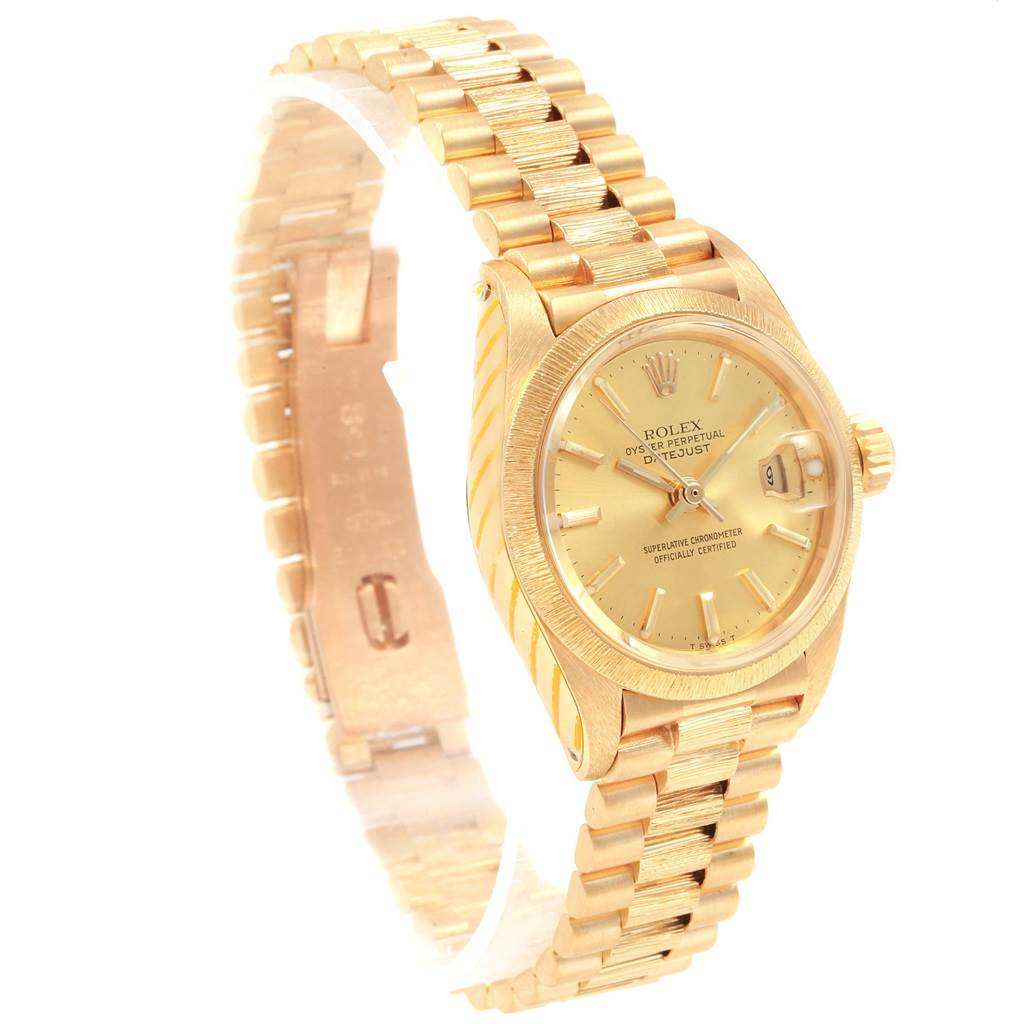 The image shows a side angle view of the Rolex President 6927 Women's Yellow Gold Champagne Dial 6927 Women's Yellow Gold Champagne Dial model, displaying its gold bracelet, dial, and crown.