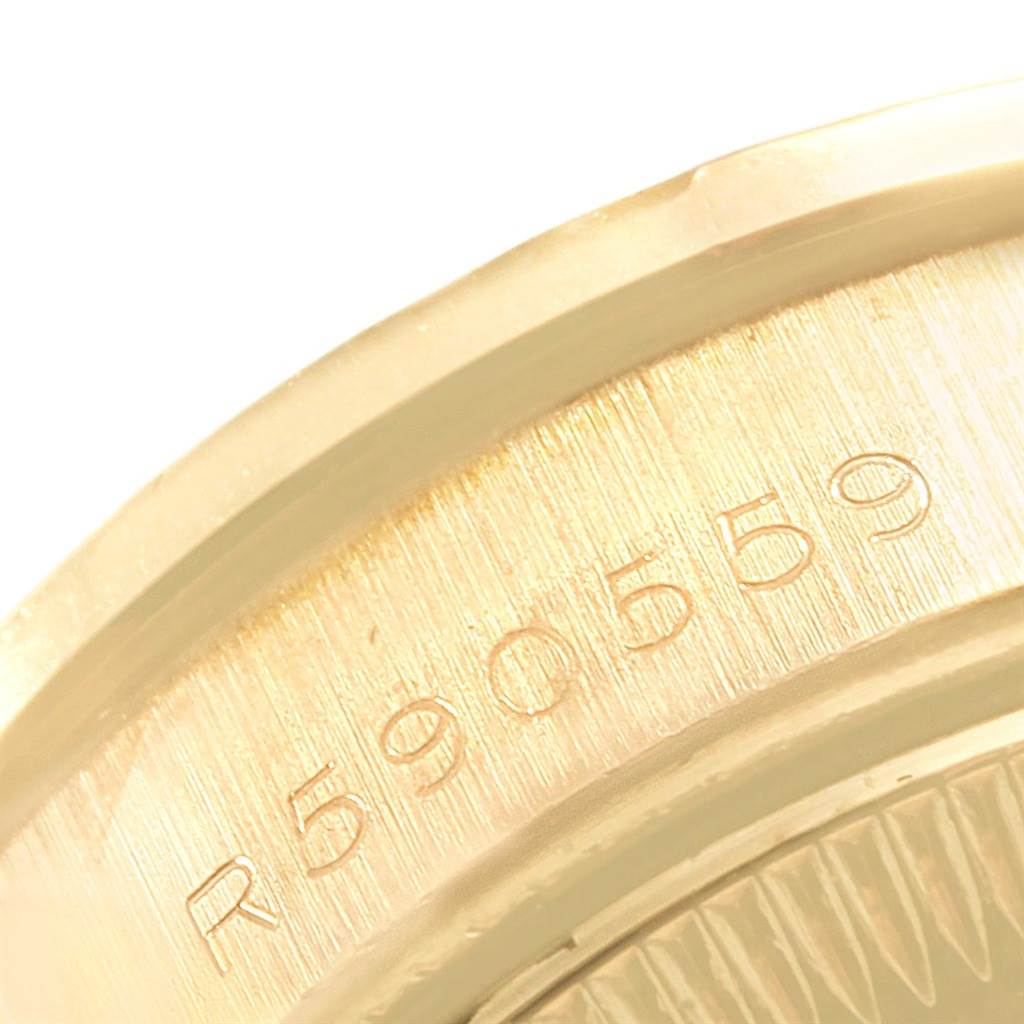 The image shows a close-up angle of the case back of a Rolex President 69158 Women's Yellow Gold Blue Dial 69158 Women's Yellow Gold Blue Dial model watch, focusing on its engraved serial number.