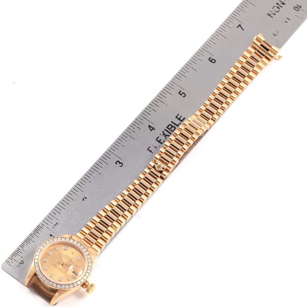 This image shows a Rolex President 79138 Women's Yellow Gold Champagne Dial 79138 Women's Yellow Gold Champagne Dial model watch laid flat next to a ruler, displaying the face, bezel, and bracelet.