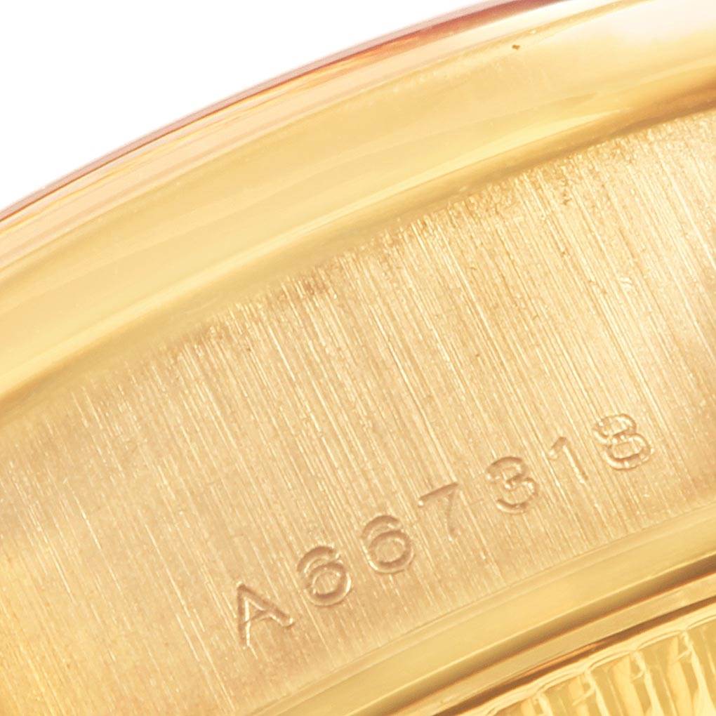 This image shows a close-up of the Rolex President 79138 Women's Yellow Gold Champagne Dial 79138 Women's Yellow Gold Champagne Dial model's gold casing with a visible serial number.